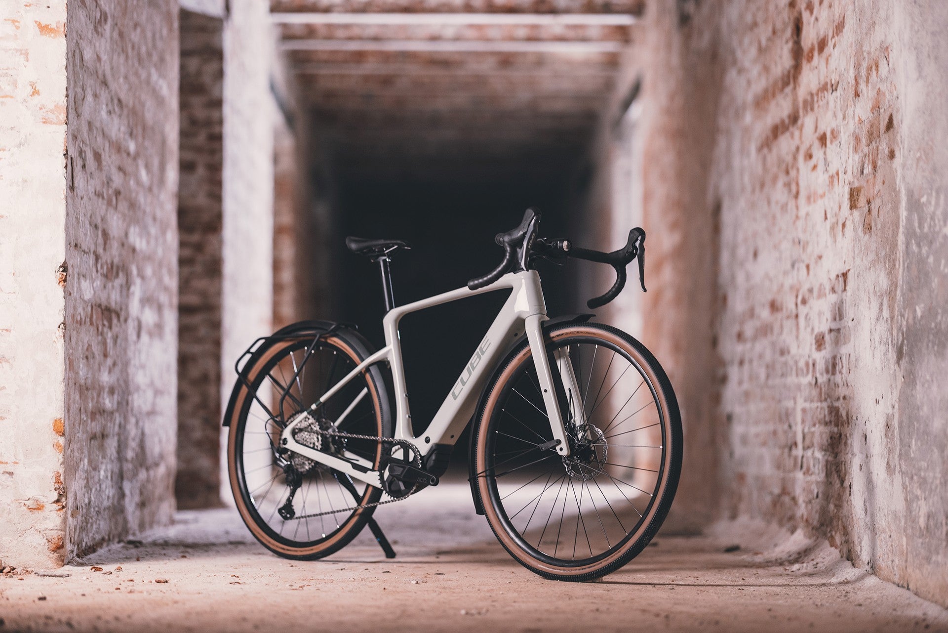 Cube Nuroad Hybrid, ein elegantes E-Bike für vielseitige Fahrten, steht in einem Backstein-Tunnel.