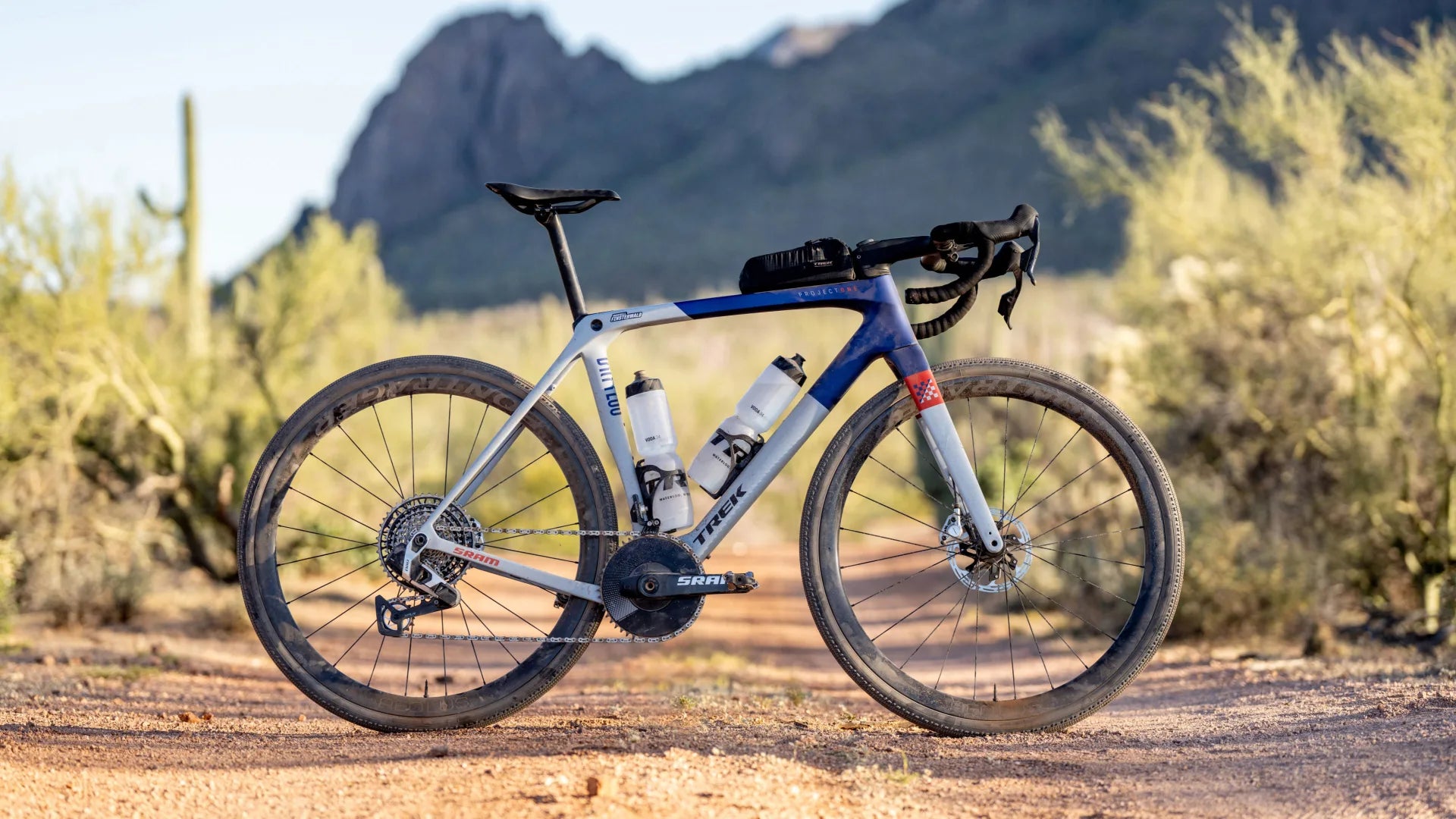 Gravelbike Trek Checkmate auf einem Wüstenpfad, ideal für Offroad-Abenteuer, mit zwei Trinkflaschen ausgestattet.