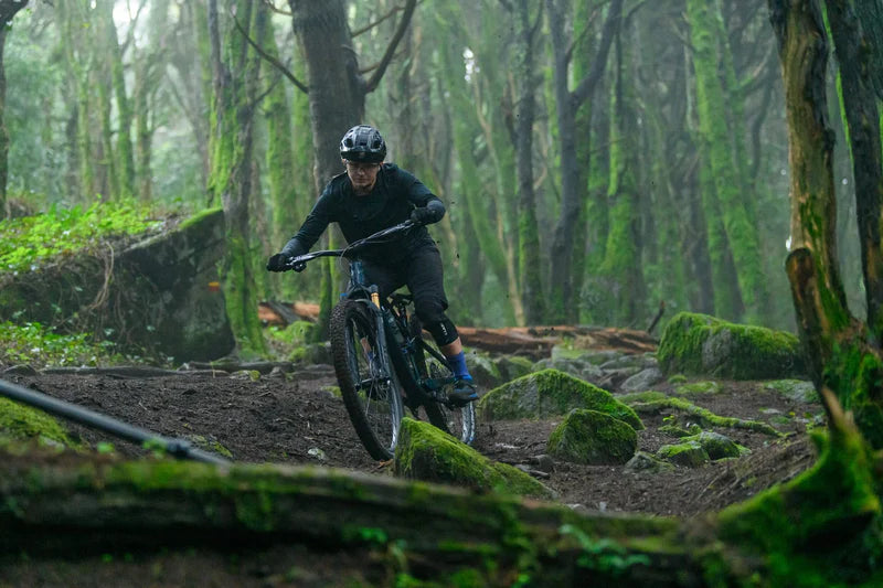 Mountainbiker fährt auf Cube-Fully durch moosigen Wald. Ideal für Abenteurer und Offroad-Enthusiasten.