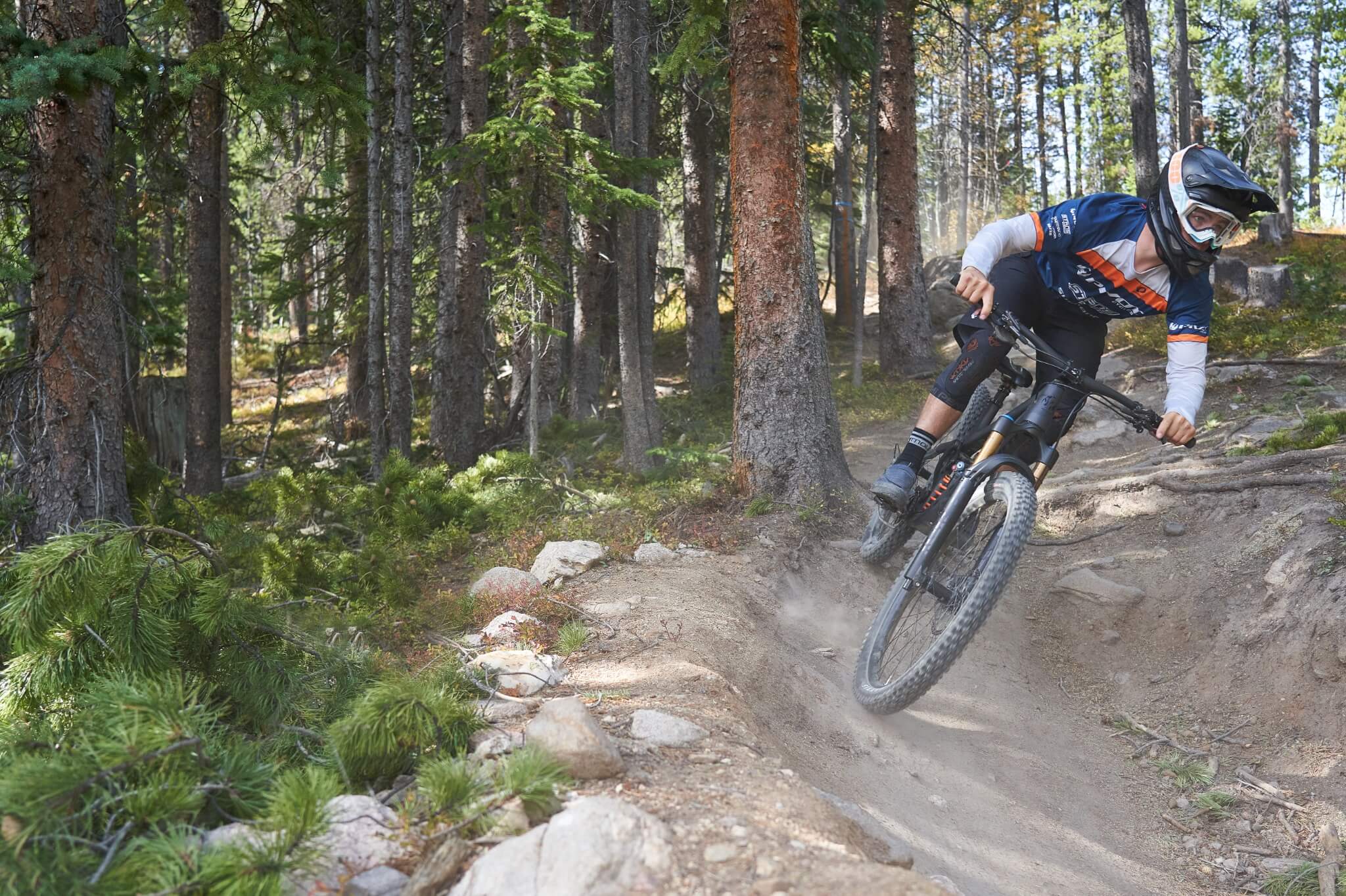 Mountainbiker fährt durch bewaldeten Trail mit Pivot Mach 6 Fahrrad, ideal für Offroad-Enthusiasten und Abenteurer.