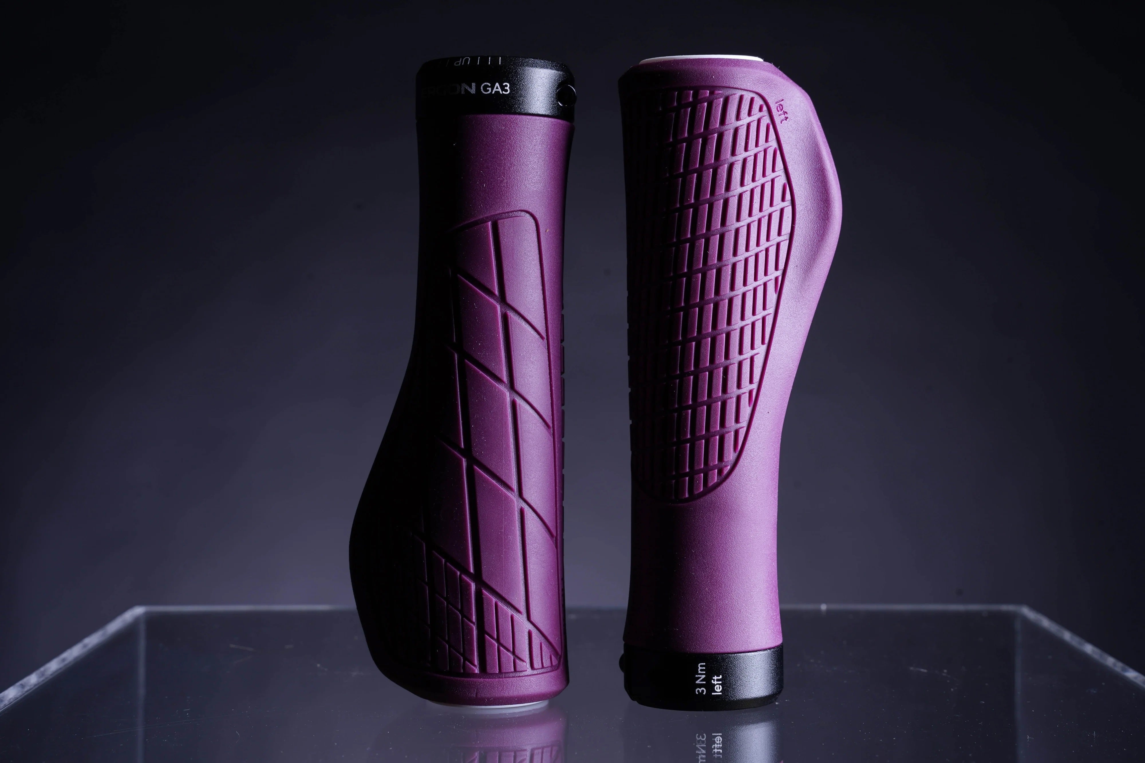 Ergon GA3 Fahrradgriffe in Lila auf schwarzem Hintergrund, ergonomisches Design für komfortables Fahren.