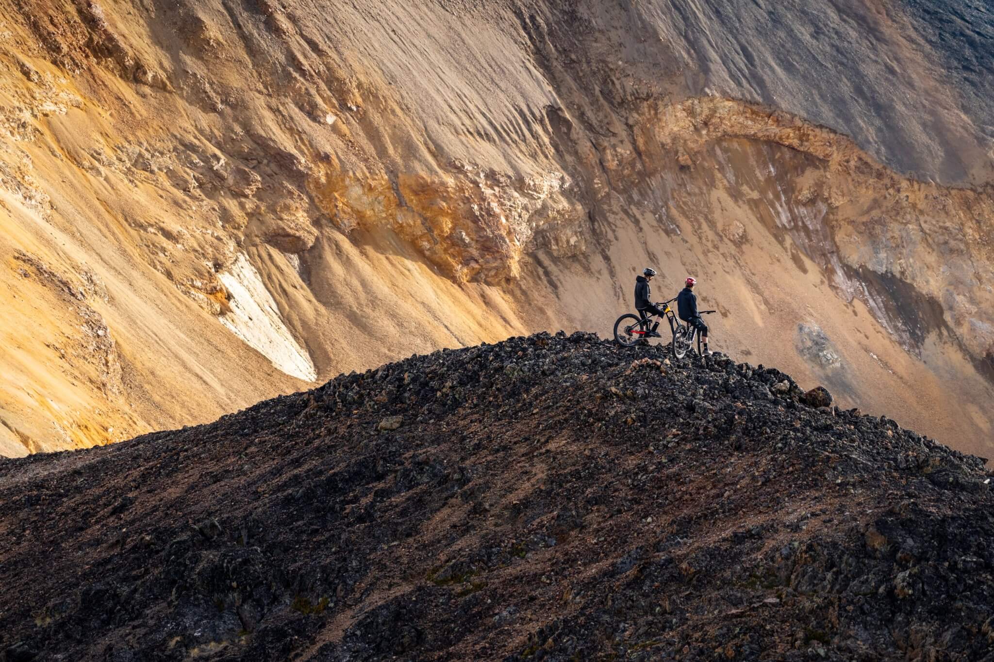 Zwei Mountainbiker auf einem felsigen Hügel, wohl mit Trek Rail Bikes, geeignet für anspruchsvolle Geländeabenteuer.