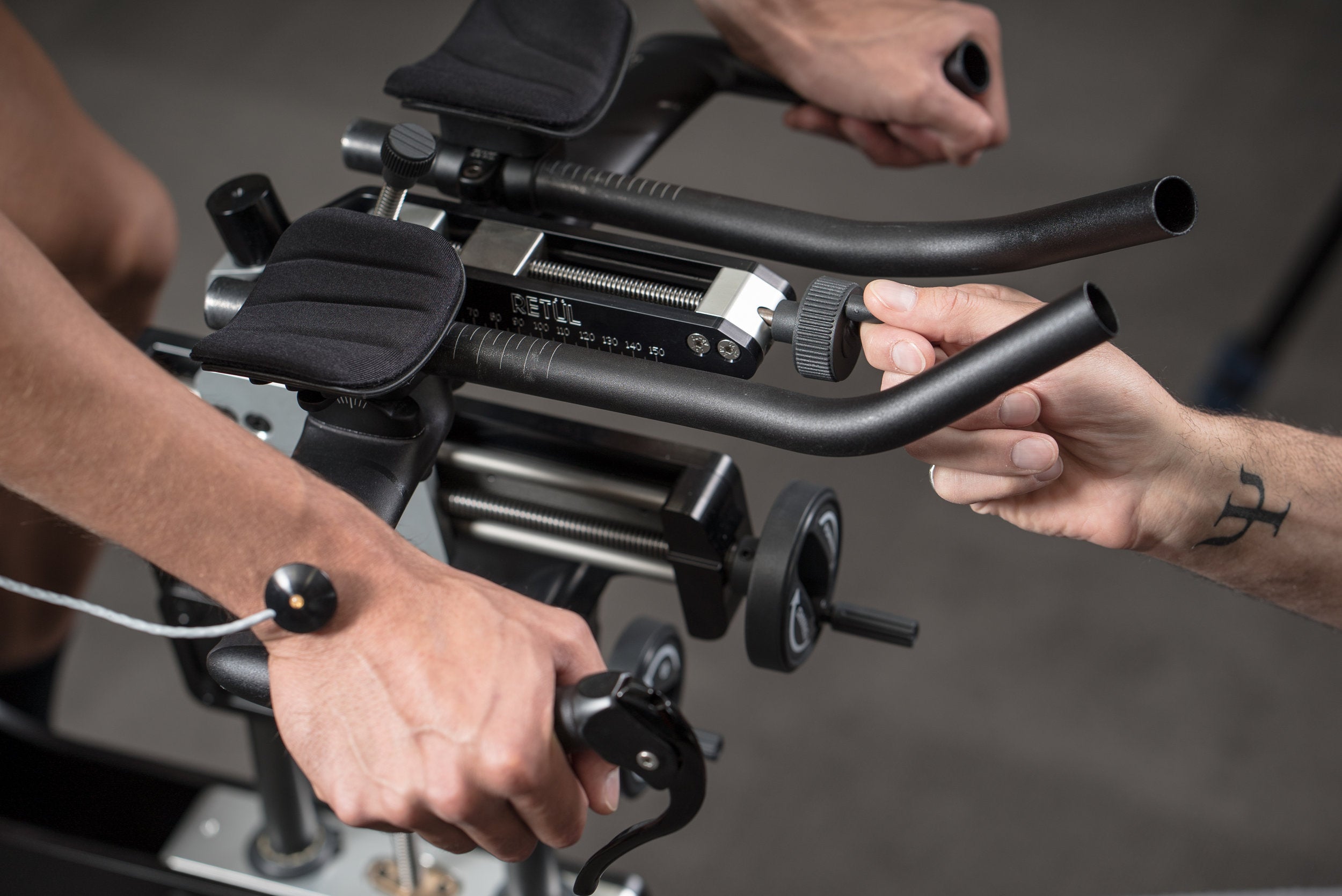 Einstellbare Fahrradlenker mit Armauflagen beim Bike Fit, Retül-Logo sichtbar, geeignet für individuelle Anpassungen.