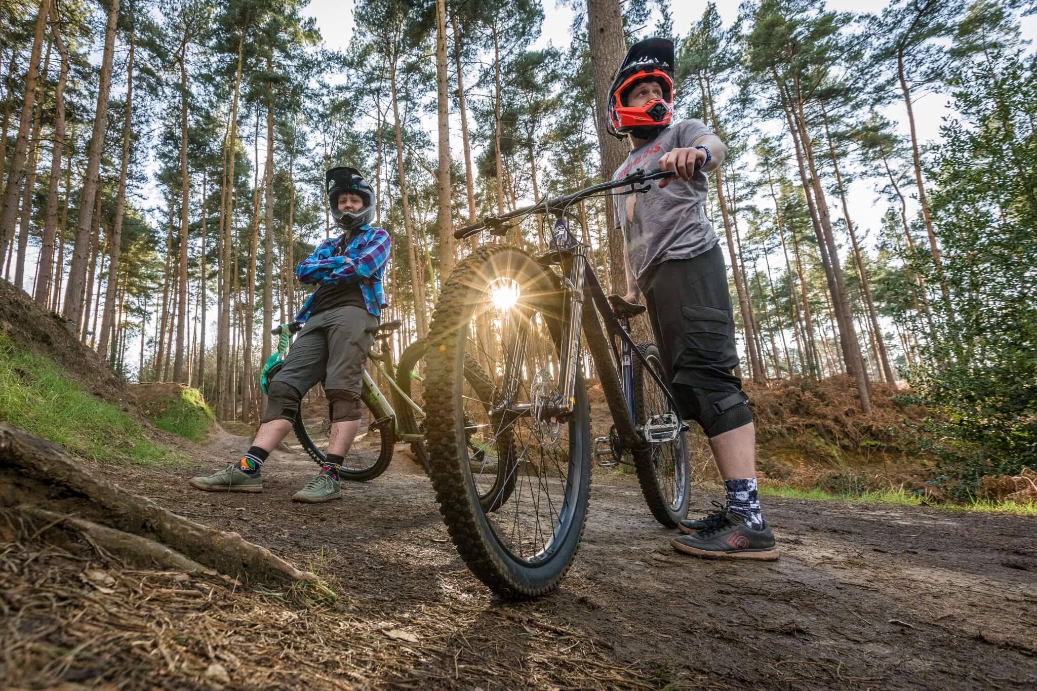 Zwei Personen mit Helmen neben GT Zaskar Hardtail-Mountainbikes im Wald, ideal für Mountainbike-Enthusiasten.