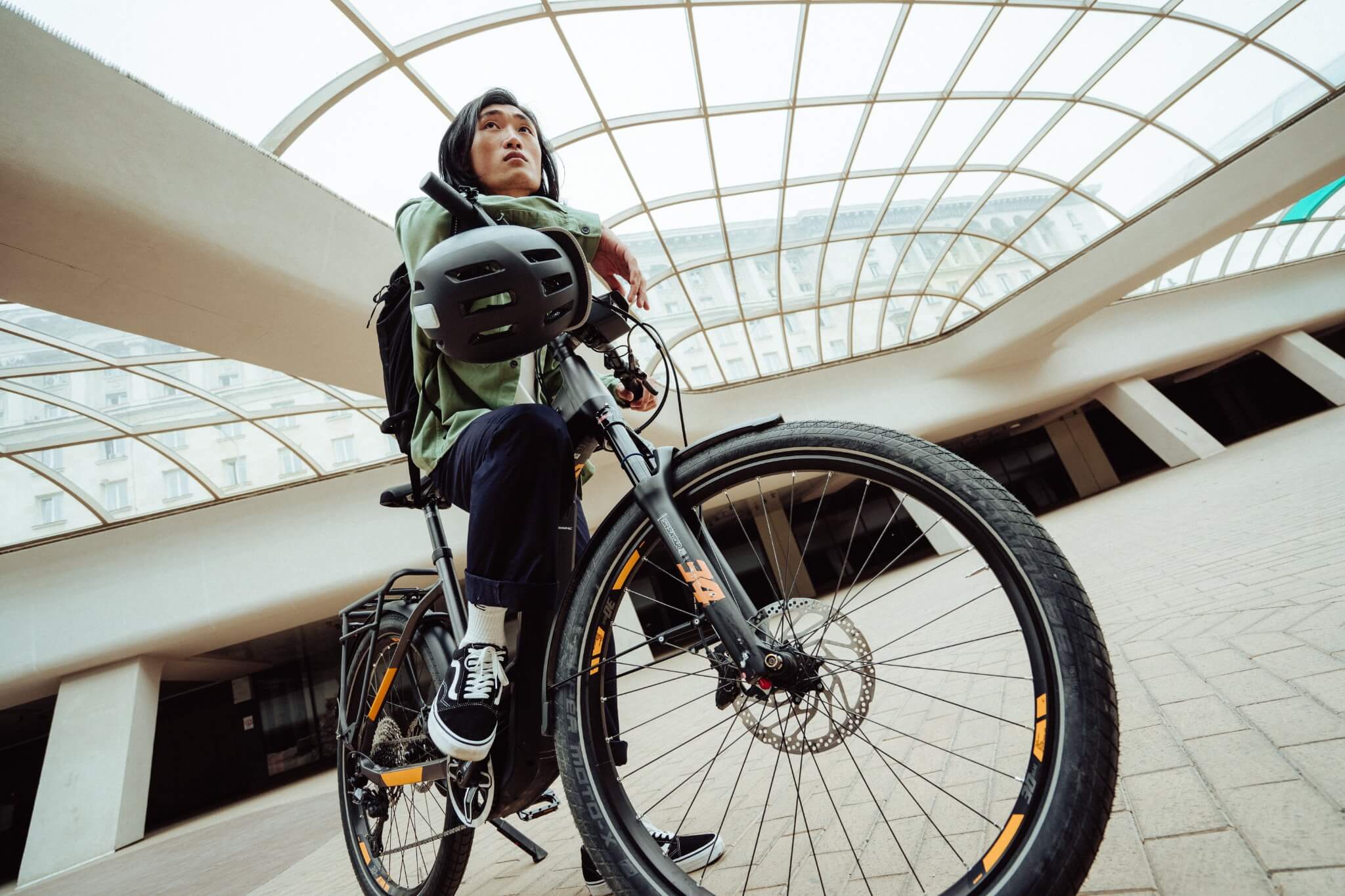 Person auf einem Haibike Trekkingrad mit Fahrradhelm in moderner Umgebung. Ideal für urbane Pendler.