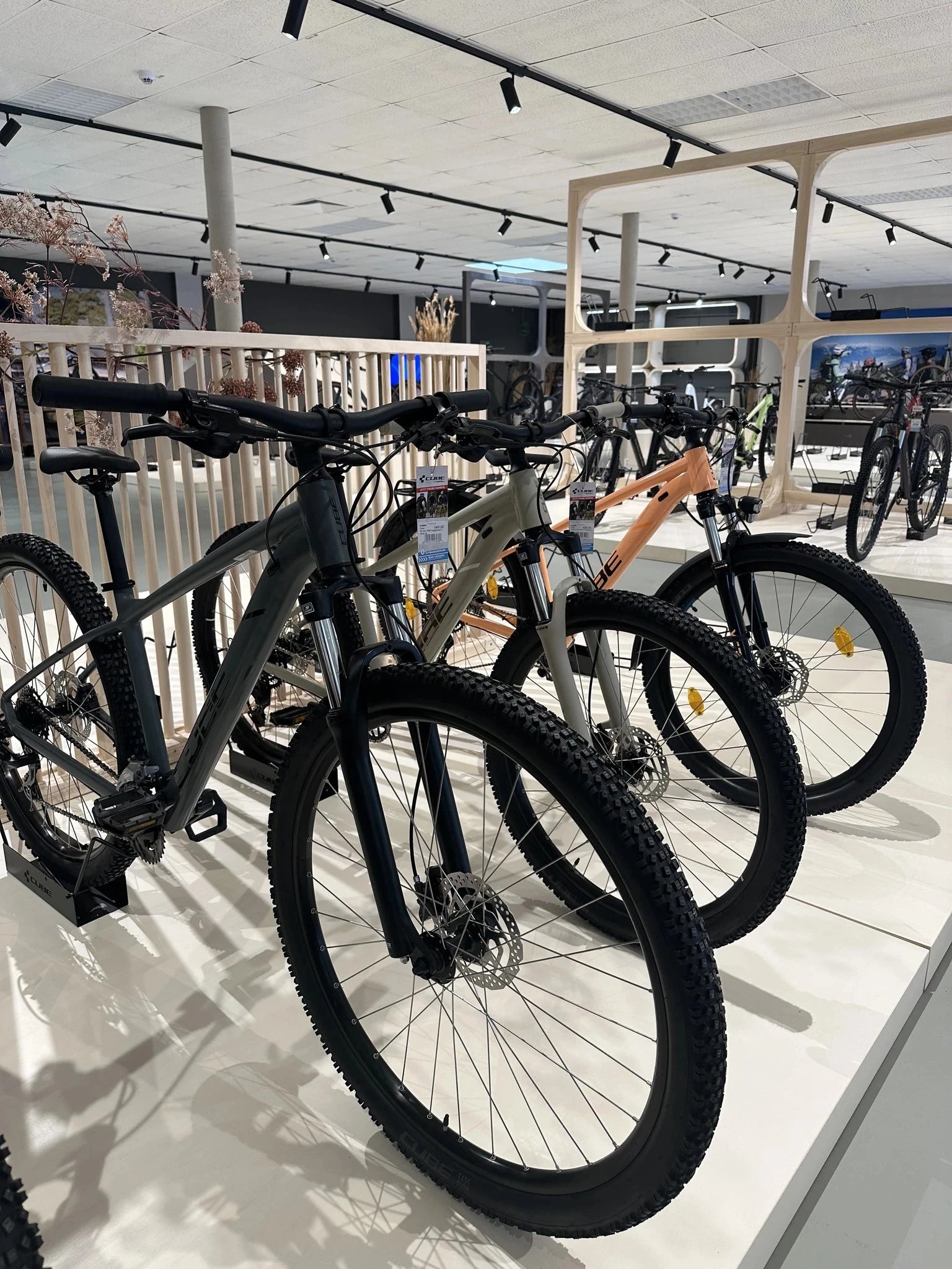 Drei Cube Mountainbikes in einem modernen Fahrradgeschäft, ideal für Radsportbegeisterte und Outdoor-Abenteuer.