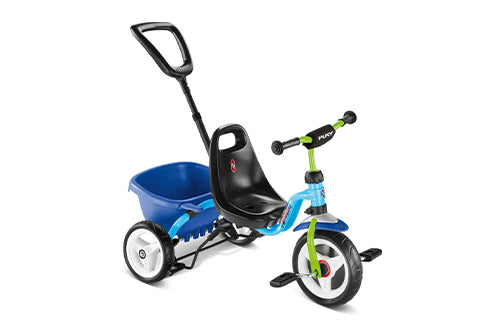 Blaues Kinder-Dreirad mit Schiebestange und Korb, geeignet für Kleinkinder. Marke Puky, Modell nicht erkennbar.