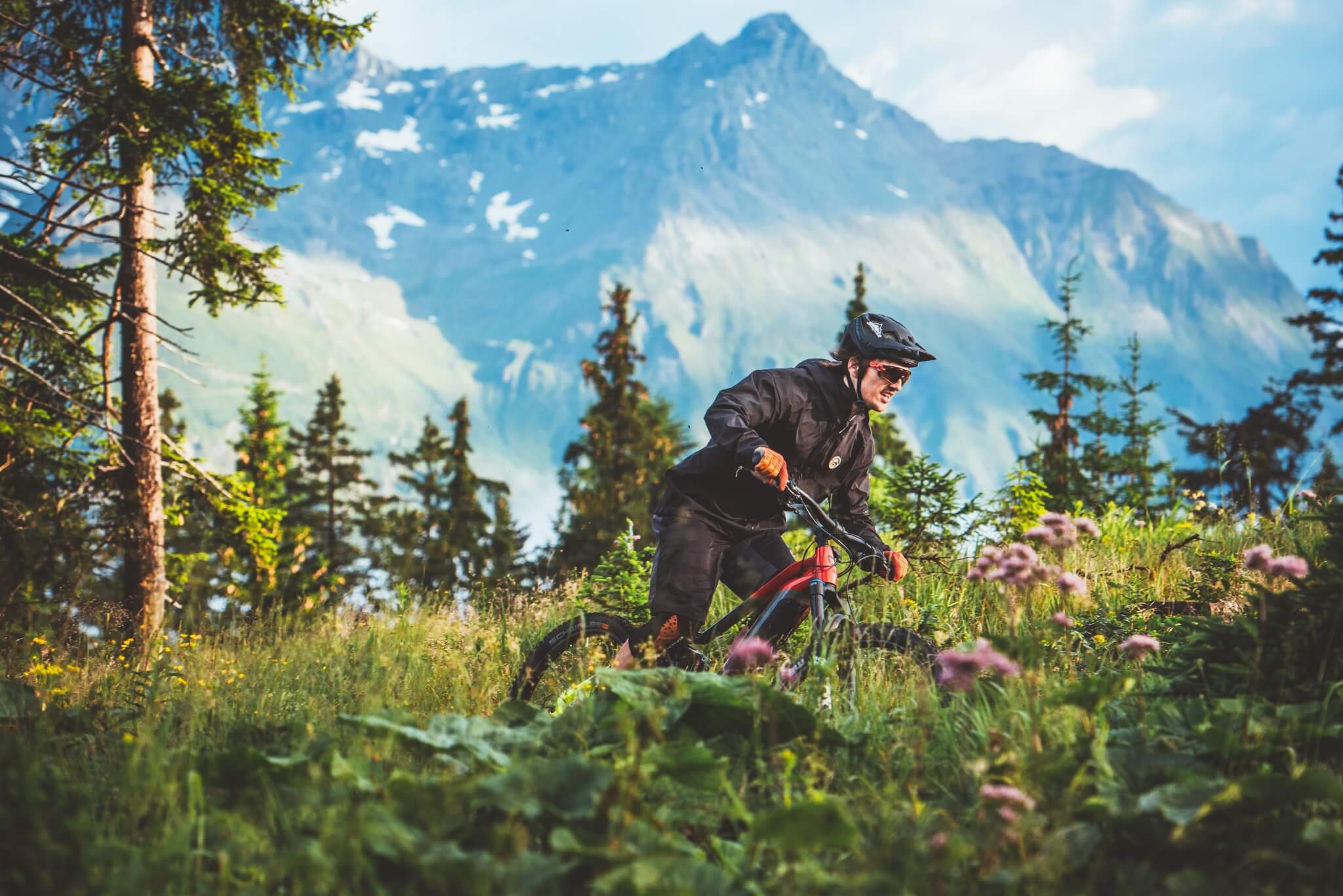 Person mit Haibike E-Mountainbike auf Waldweg vor Bergkulisse, geeignet für Outdoor-Abenteuer.