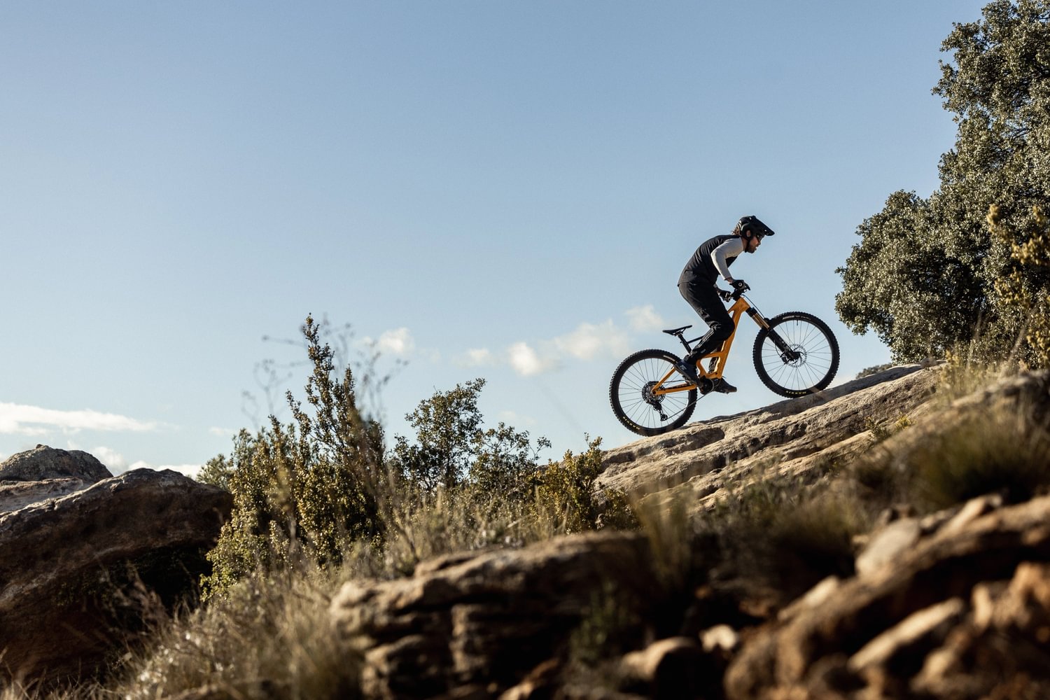 Person fährt mit einem Orbea Rise E-Mountainbike einen felsigen Hügel hinauf, geeignet für Outdoor-Abenteuer.