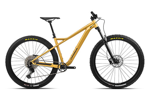 Gelbes Orbea Hardtail Mountainbike mit Maxxis-Reifen, Scheibenbremsen und Shimano-Antrieb, seitliche Ansicht.