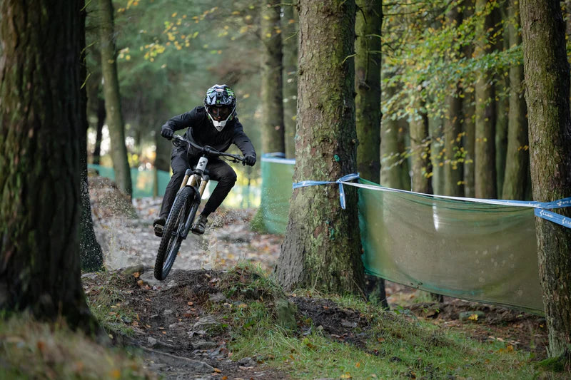 Mountainbiker auf malerischer Waldstrecke mit Helm; Cube Fully, ideal für Offroad-Abenteuer.