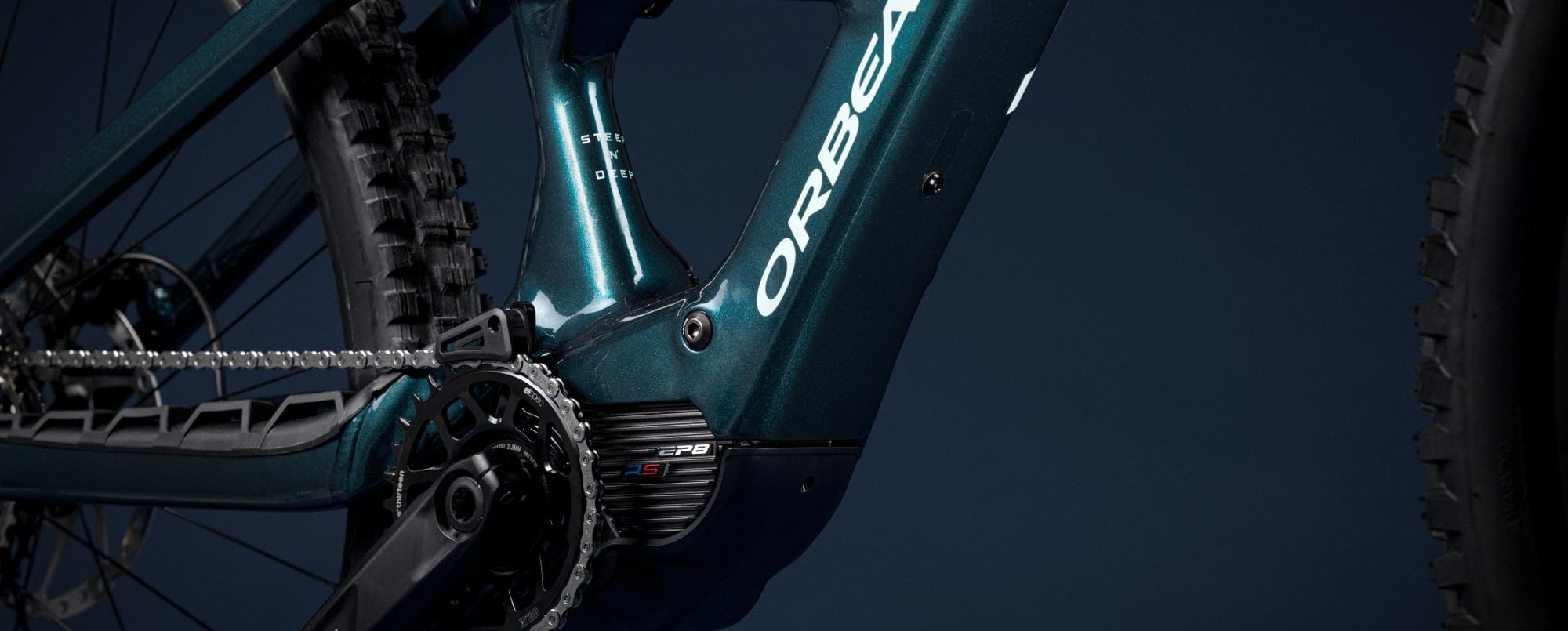 Orbea Rise E-Mountainbike, Detailansicht des Rahmens und Kettenblatts in dunklem Blau, geeignet für Offroad-Abenteuer.