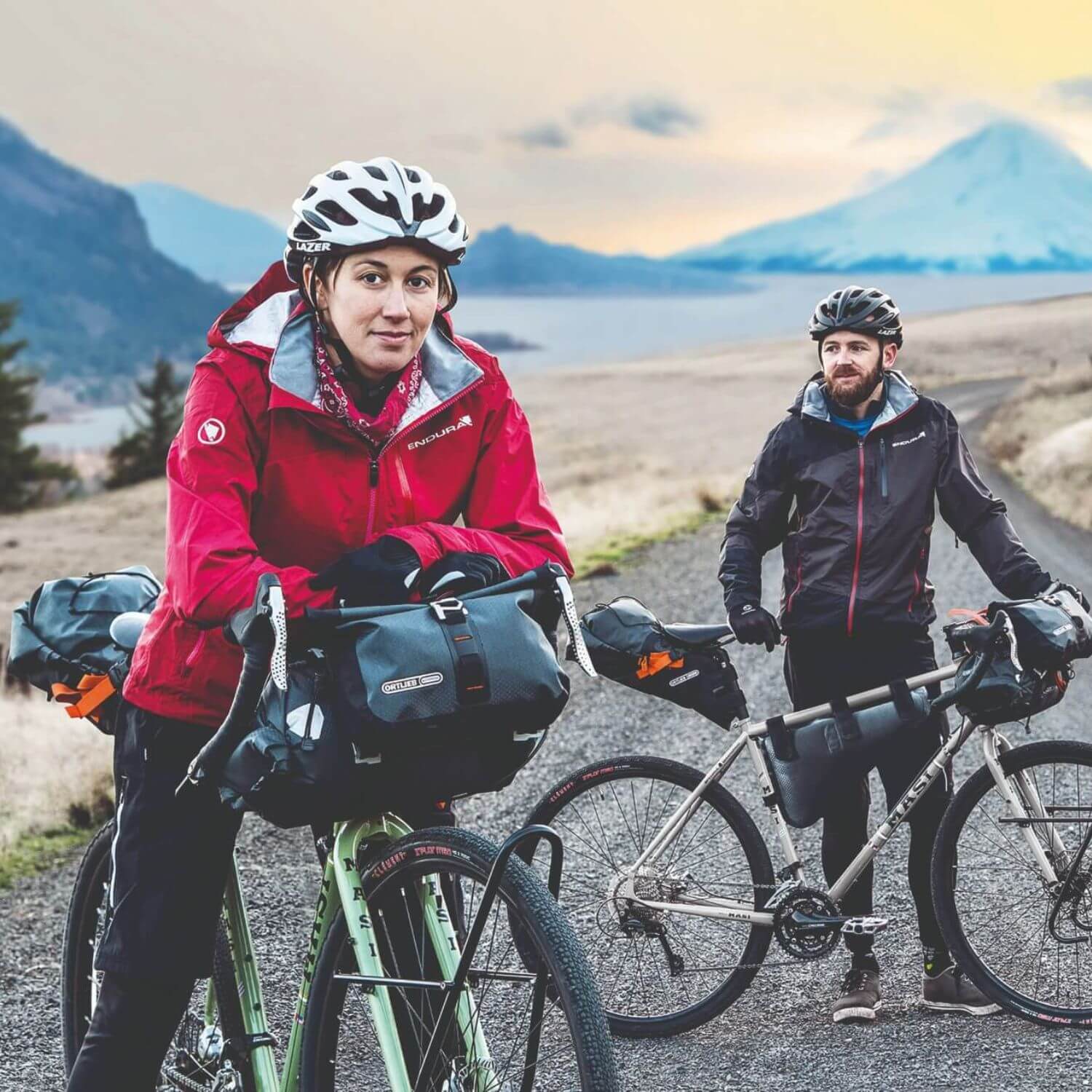 Zwei Radfahrer mit Ausrüstung auf einem Schotterweg in der Natur, tragen Endura-Jacken und Lazer-Helme.