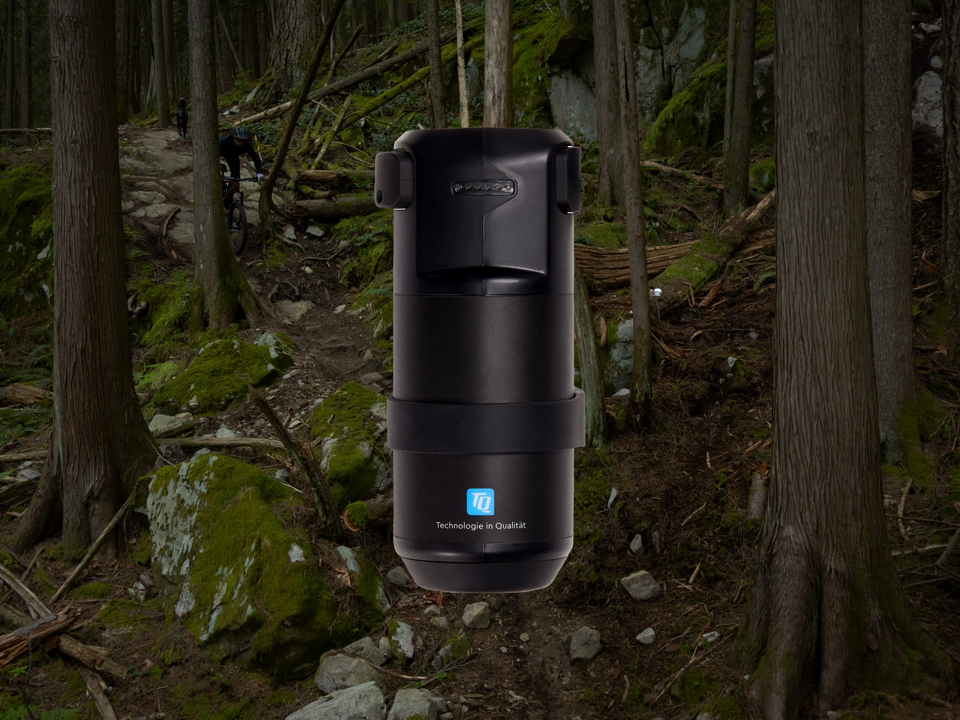 Schwarzer, zylindrischer Behälter mit Quick-Lock-Mechanismus, geeignet für den Outdoor-Einsatz, umgeben von Waldumgebung.