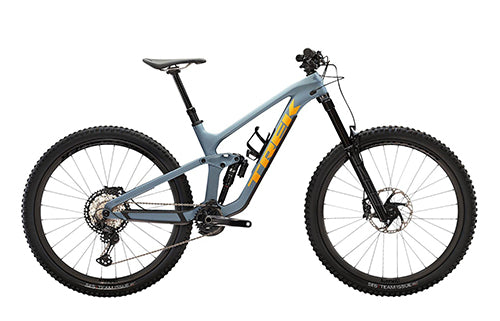 Blaues Trek Fully-Mountainbike mit gelbem Schriftzug, robuste Federung, Scheibenbremsen, geeignet für Offroad-Abenteuer.