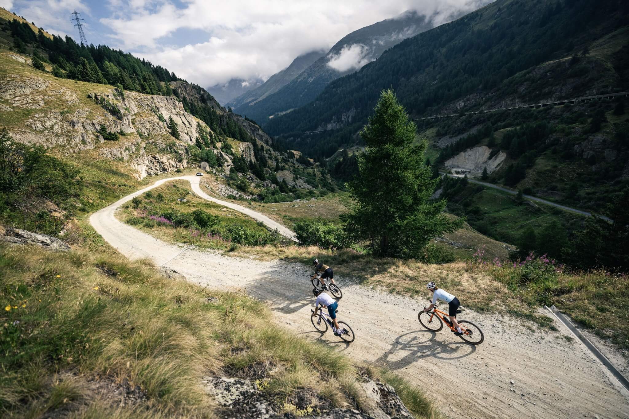 Zwei Radfahrer auf Gravel-Bikes auf einer kurvigen Bergstraße. Ideal für Outdoor- und Sportbegeisterte.