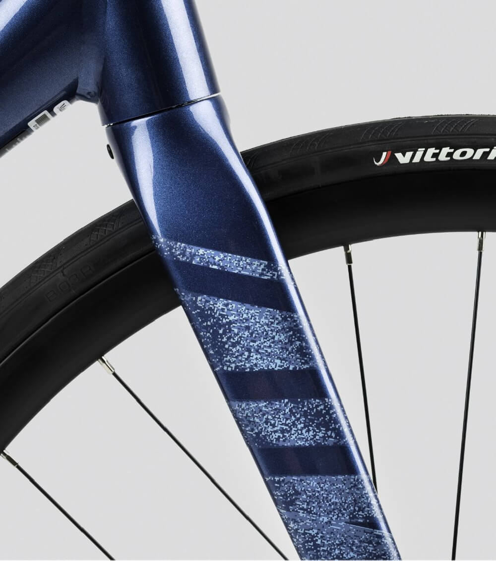 Nahaufnahme eines blauen Straßenfahrradrahmens Orbea Avant mit einer Vittoria-Reifenmarke. Ideal für Radfahrer.