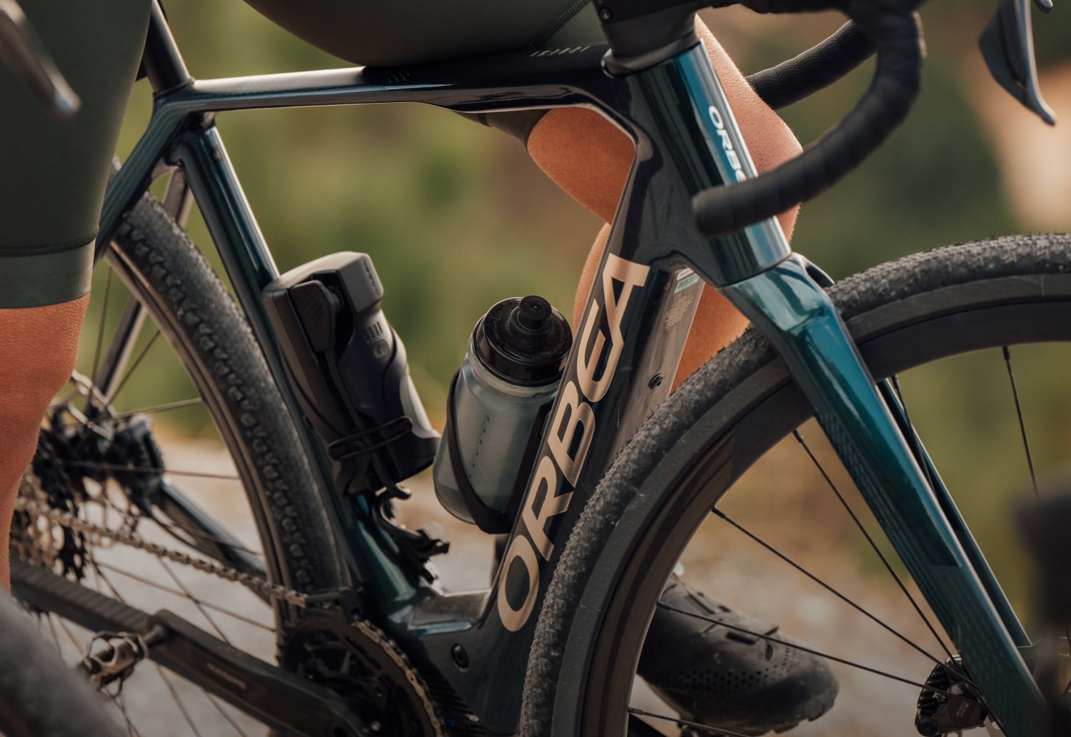 Orbea Fahrrad mit Trinkflasche, ideal für sportliches Fahren auf unbefestigten Wegen.