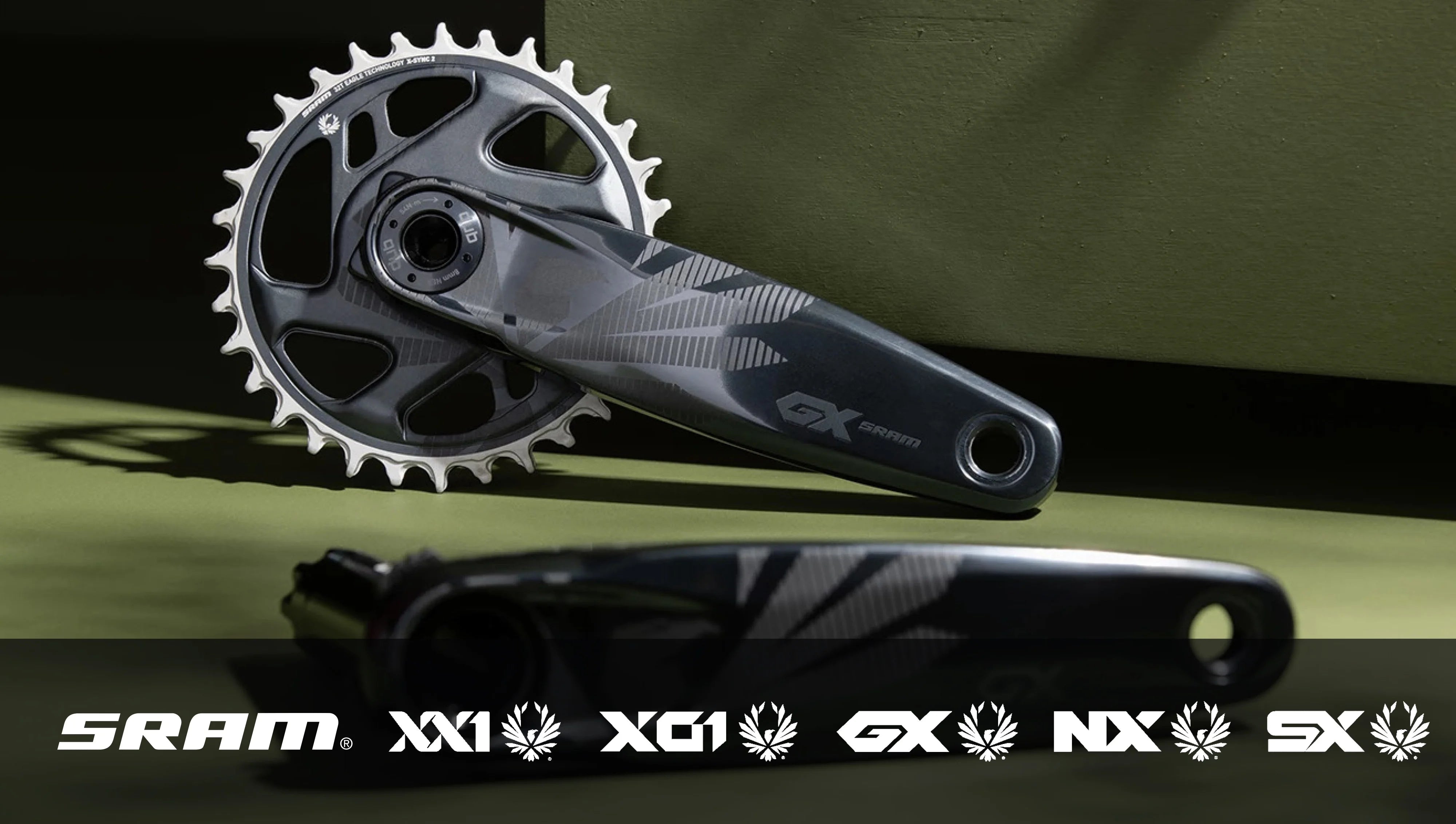 SRAM GX Eagle Kurbelgarnitur mit 52-Zahn-Kettenblatt, für Mountainbikes, präsentiert vor grünem Hintergrund.