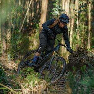 Person fährt Mountainbike Cube Stereo One44 durch einen Waldpfad.