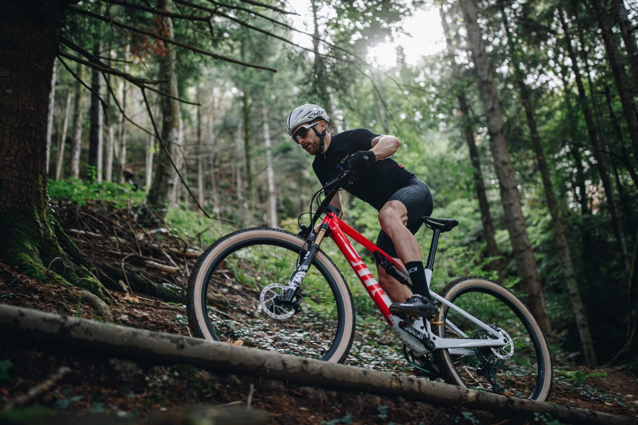 Mann fährt ein BMC Fourstroke Mountainbike im Wald, geeignet für sportliche Offroad-Touren.