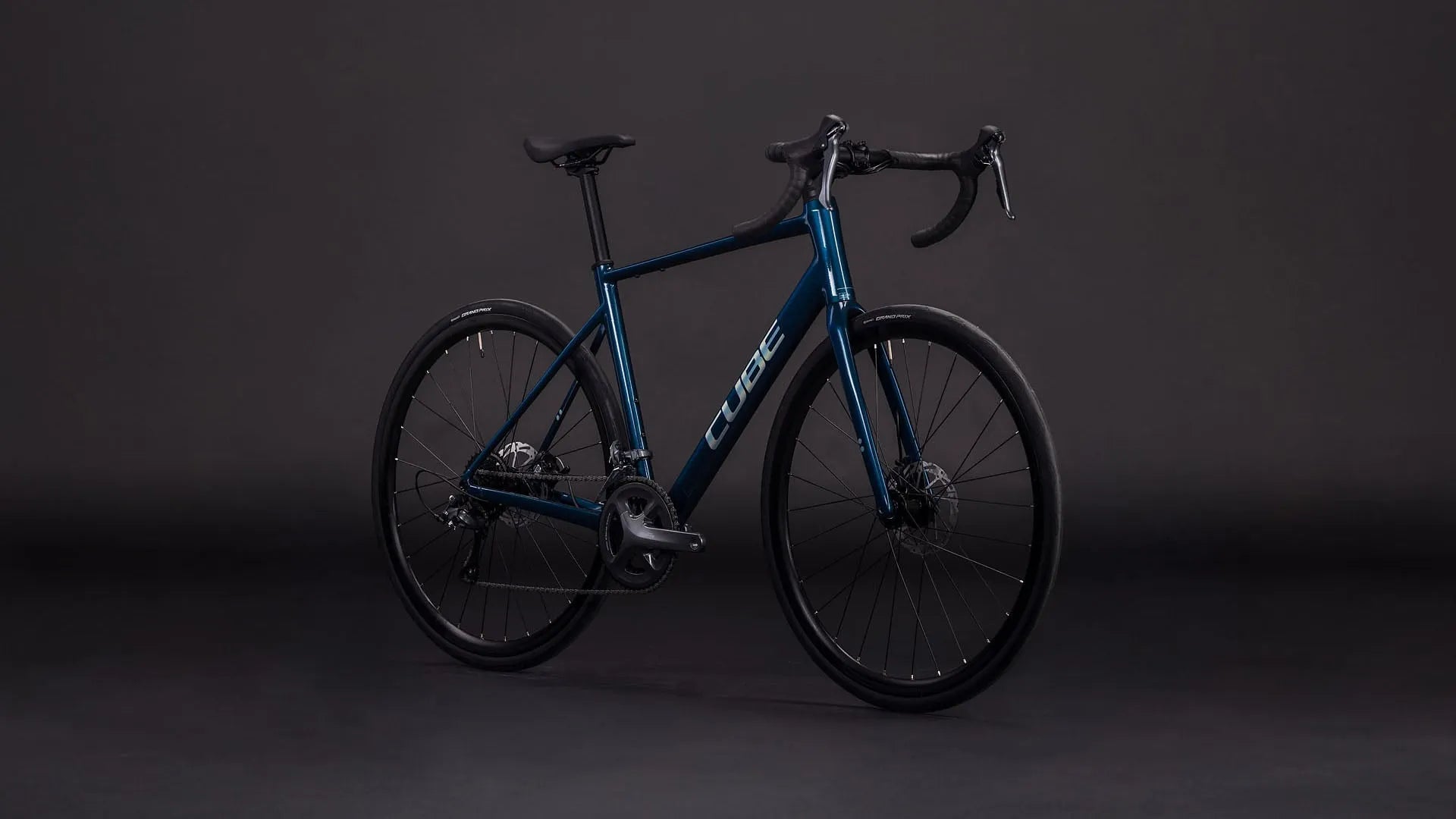 Cube Attain Pro in Dunkelblau, geeignet für sportliche Fahrer, im Profil vor dunklem Hintergrund.