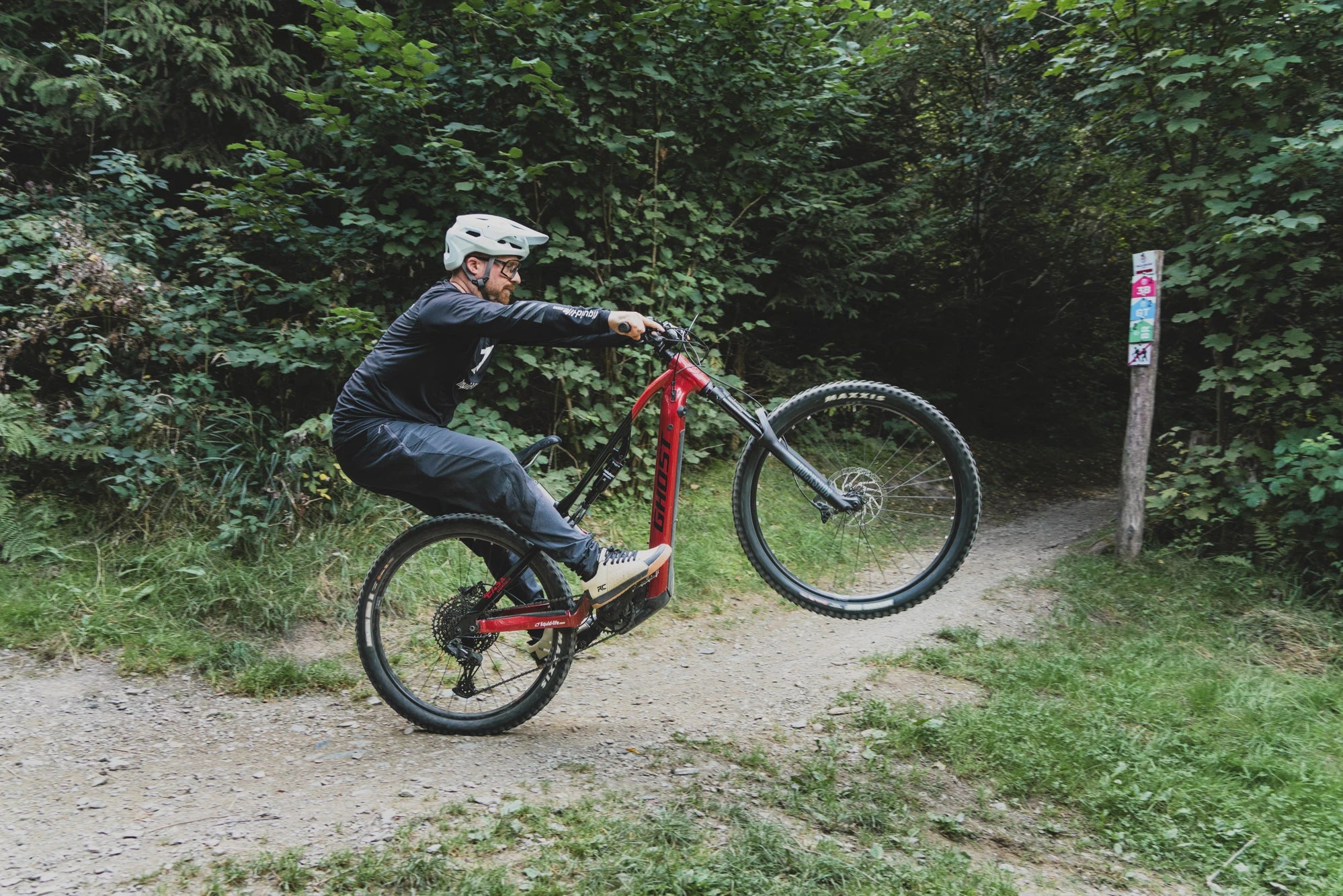 Marc Brodesser macht einen Wheelie mit  einem Ghost E-MTB  im Trailgorund Brilon