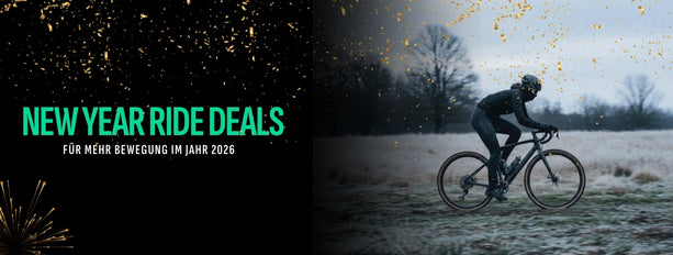 Radfahrer auf einem Rennrad im Freien, bewölkter Himmel, Text: "New Year Ride Deals, für mehr Bewegung im Jahr 2026".