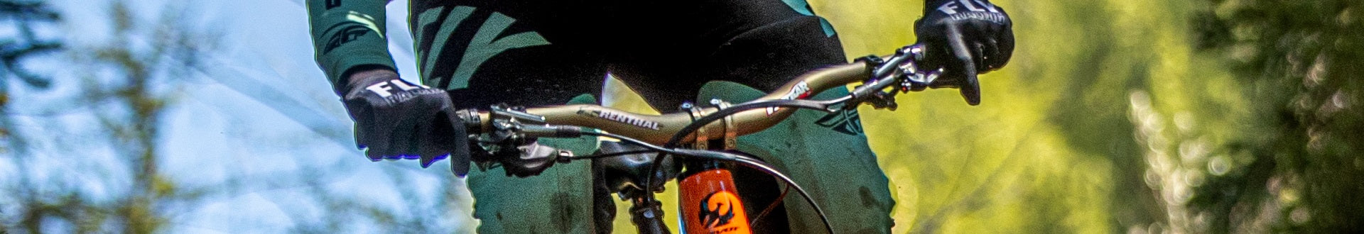 Mountainbiker auf Pivot E-MTB im Gelände, Nahaufnahme des Lenkers mit Ergon-Griffen und Renthal-Vorbau.