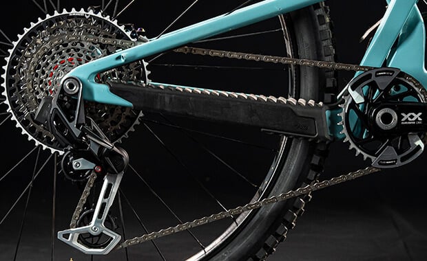 Nahaufnahme eines Fahrrad-Hinterrads mit Kettenantrieb und Schaltung, geeignet für Mountainbikes.