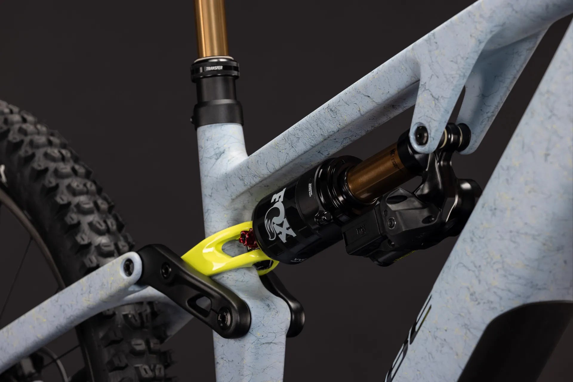 Detailaufnahme eines CUBE AMS HYBRID 177 C:62 SUPER TM 600X
Mountainbike-Dämpfers FOX mit gelbem Verbindungsstück und robustem Carbonrahmen.