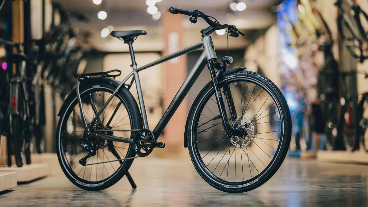 Modernes Cube KATHMANDU SLT
2027 mit Scheibenbremsen steht in einem Fahrradladen, ideal für Stadt und Touren.