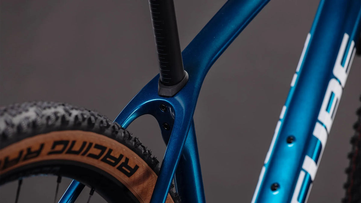 Nahaufnahme eines blauen Cube Reaction C:62 SLX Carbon Rahmen mit Fokus auf Rahmen und Reifen, geeignet für Mountainbiking.