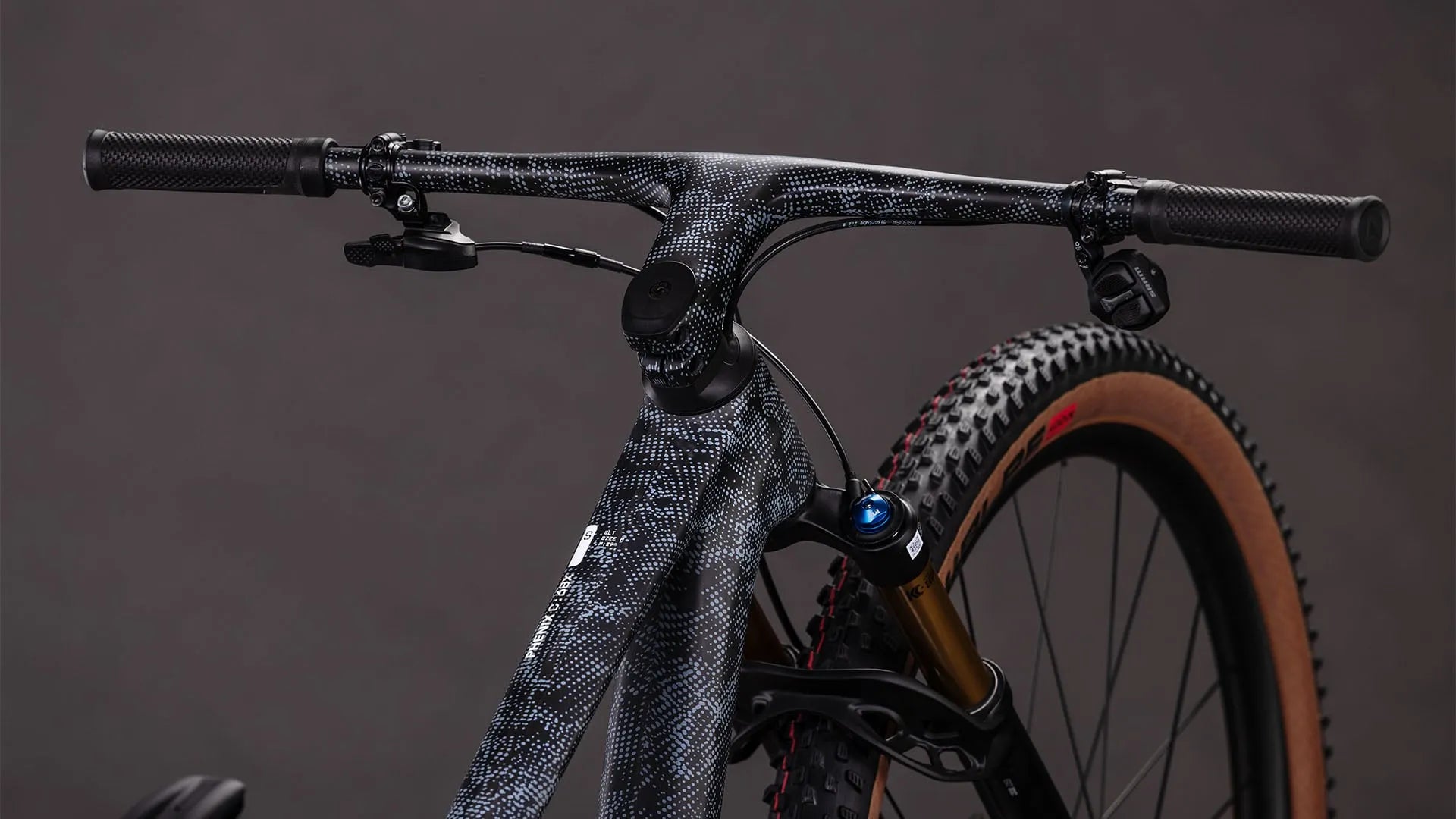 CUBE PHENIX C:68X SLX mit gemustertem Rahmen, breiten Reifen und Scheibenbremsen, geeignet für Offroad-Radfahren.